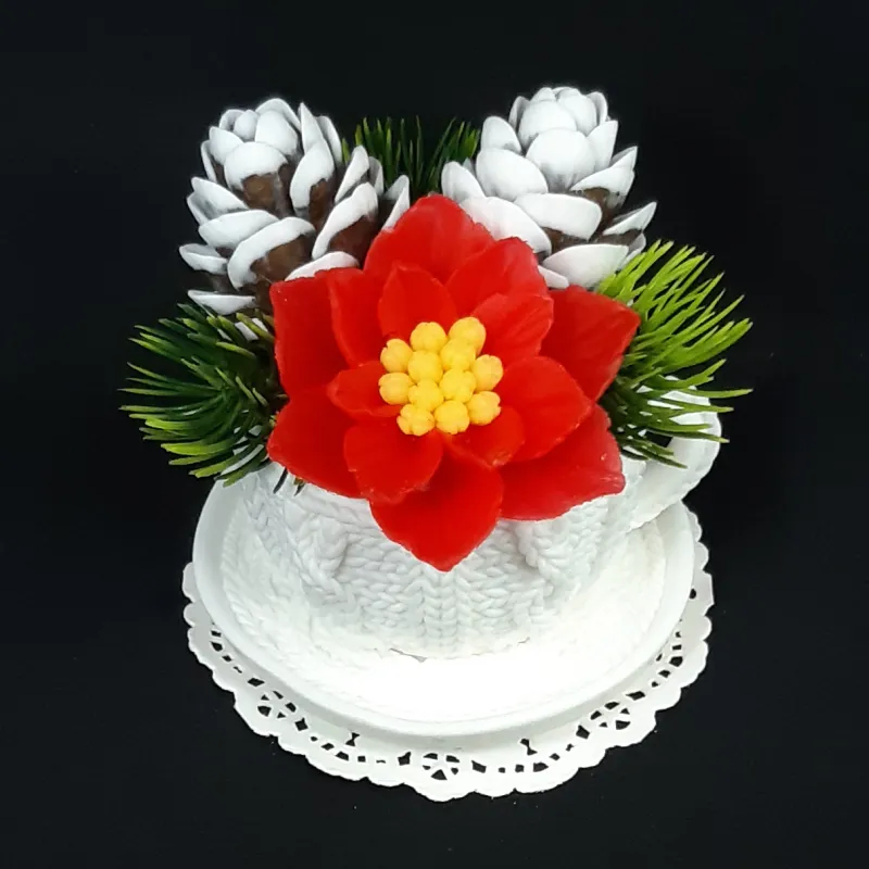 Bela šolja sa crvenom božičnom zvezdom i šišarkama