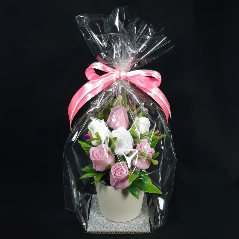 Ružičaste i bele ruže u maloj keramičkoj sakciji